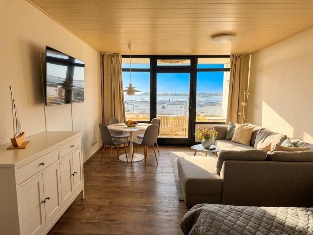 a living room with a couch and a table at Meerblick in der Meerzeitliebe Fehmarn in Fehmarn