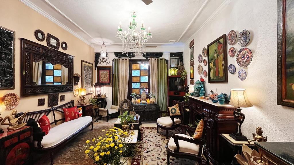 a living room filled with furniture and a chandelier at On the House homestay in New Delhi