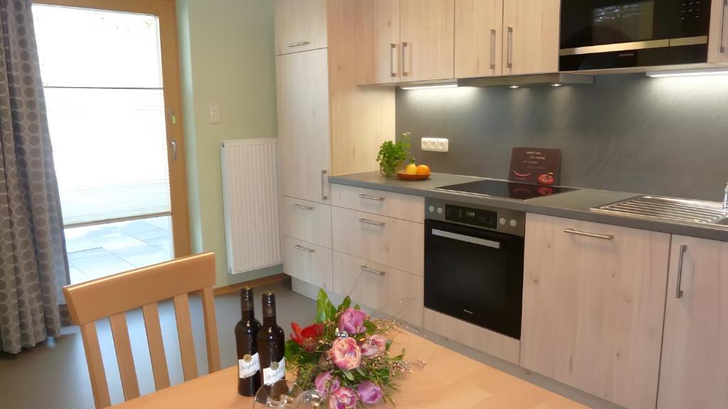 a kitchen with a table with flowers and wine bottles at Ferienwohnung Hörnle Bad Kohlgrub in Bad Kohlgrub