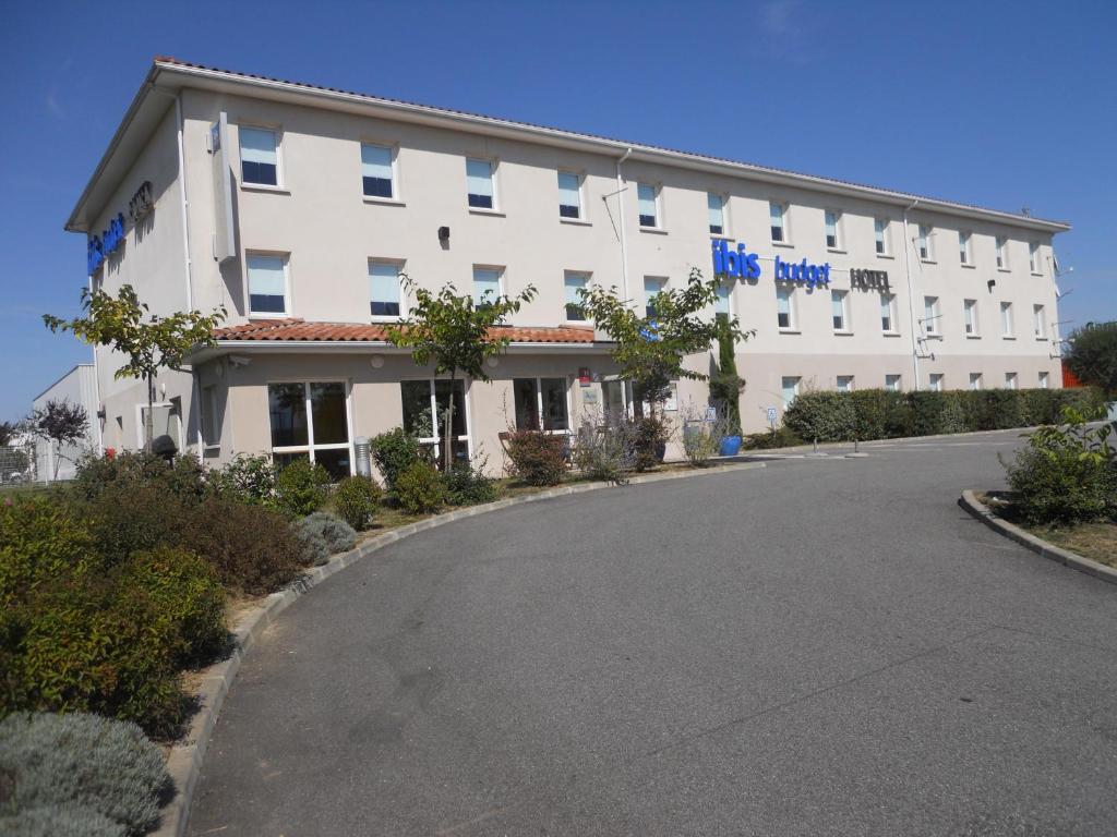 a large white building with a road in front of it at ibis budget Saint Gaudens in Estancarbon