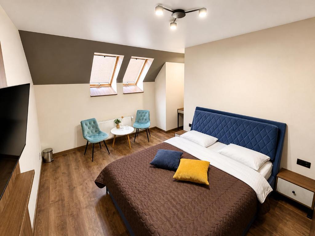 a bedroom with a large bed and two chairs at Prime Hotel in Dnipro