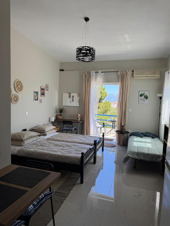 a large bedroom with two beds and a window at Bougainvillea Terrace Studio in Sikéa