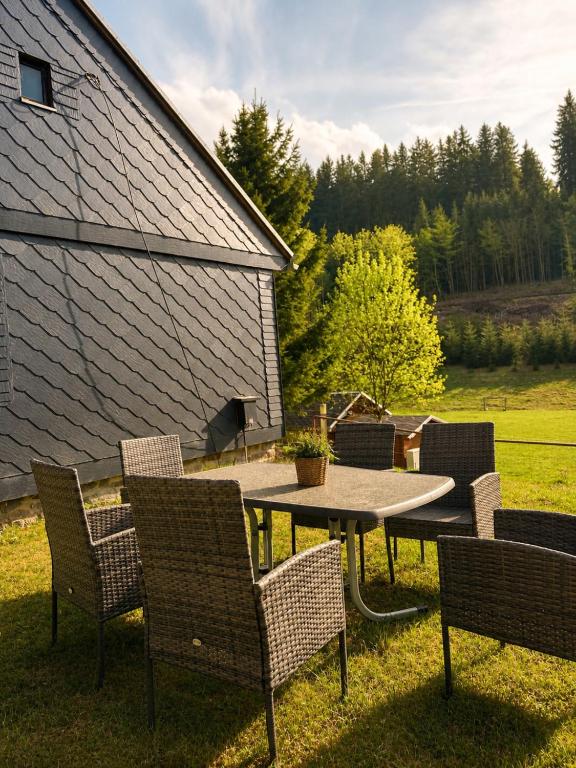 a patio with chairs and a table and a table and chairs at Ferienhaus Pfefferminzhütte in Mildenau