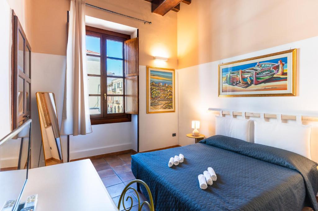 a bedroom with a blue bed in a room at Via Roma Rooms Guesthouse in Sassari