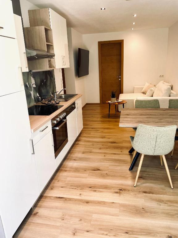 a kitchen and living room with a bed and a table at Apart Alma in Pfunds
