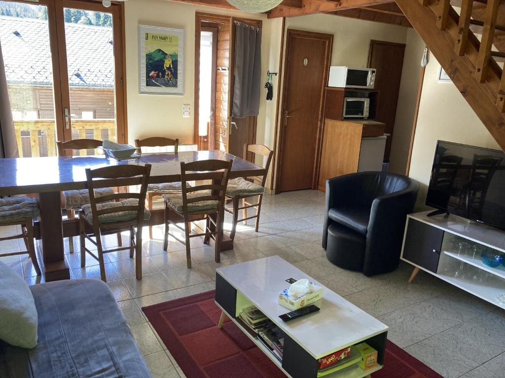 a living room with a table and a dining room at chalet du mouflon au bec aigle in Le Lioran