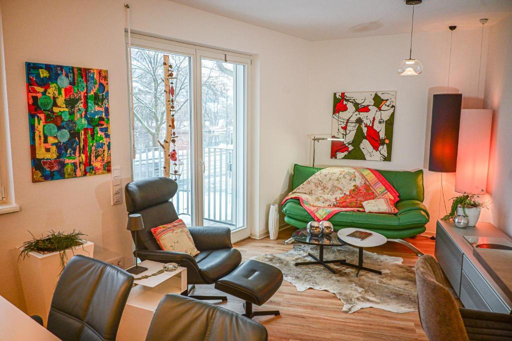 a living room with a green couch and chairs at Mainresidenz Wertheim in Wertheim