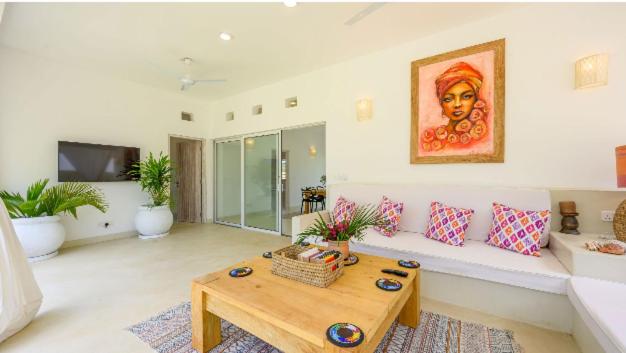 a living room with a couch and a table at Dhahabu Village - Villa 244 Beachfront stay in Mambrui