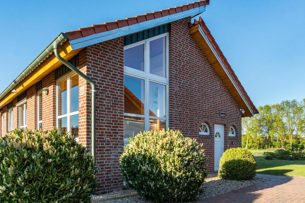 a red brick house with a large window at Ferienhaus Gut Düneburg in Haren
