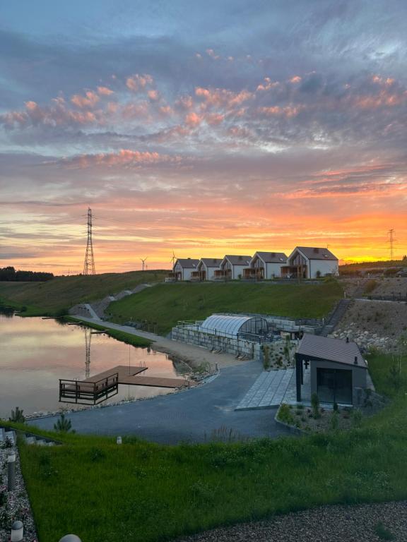 a sunset over a body of water with houses at Biała Woda in Suwałki