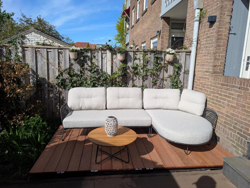 a white couch sitting on a wooden deck at Appartement Bongerdstraat in Nijmegen