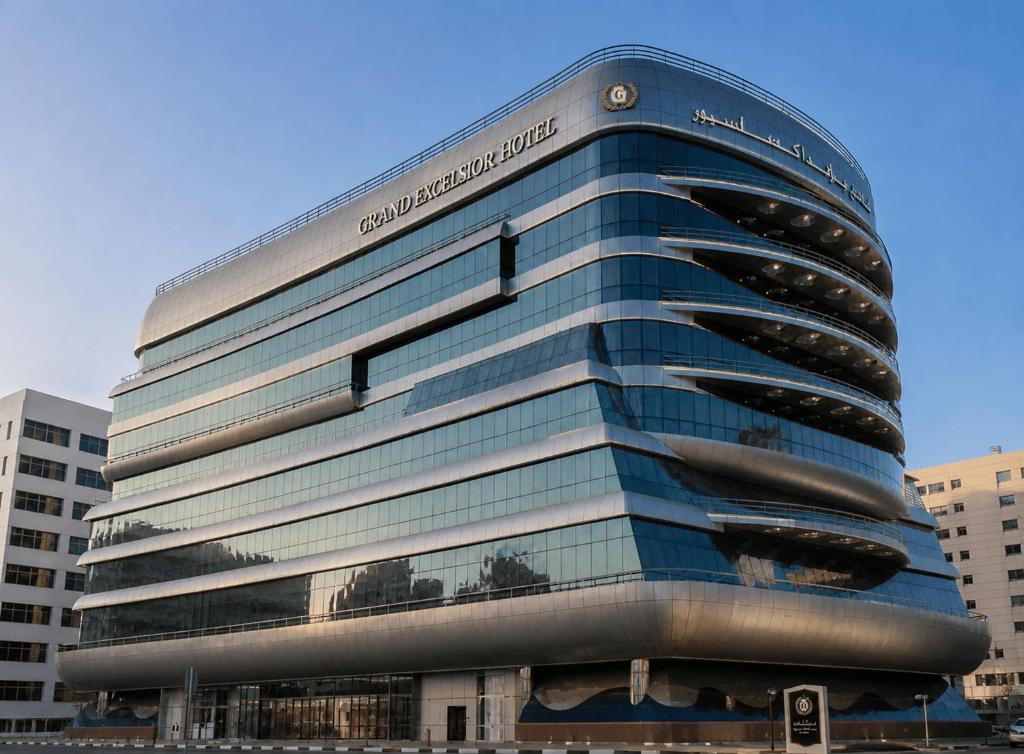 a tall glass building with a sign in front of it at Sunday Hotel Al Barsha Dubai Mall of the Emirates Formerly Grand Excelsior Al barsha in Dubai