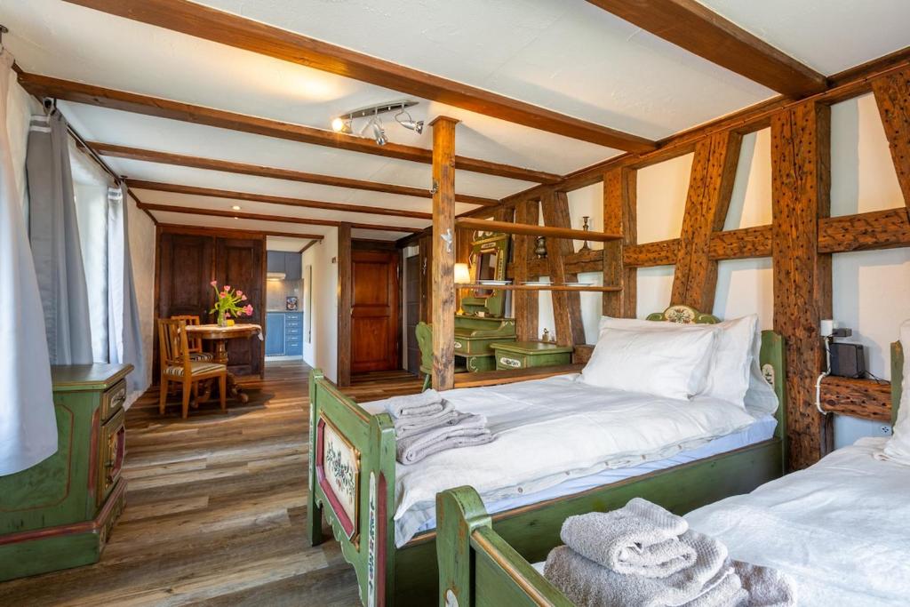 a bedroom with two beds in a room with wooden floors at Charming Swiss Lake View studio apartment in Wädenswil