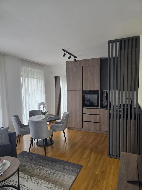 a living room with a table and chairs and a television at Aura Apartmani Vrnjačka Banja in Vrnjci