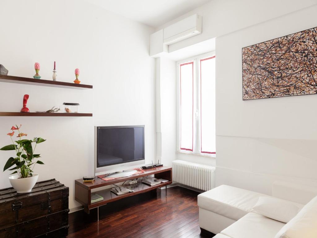 a living room with a white couch and a tv at Trastevere Art House in Rome