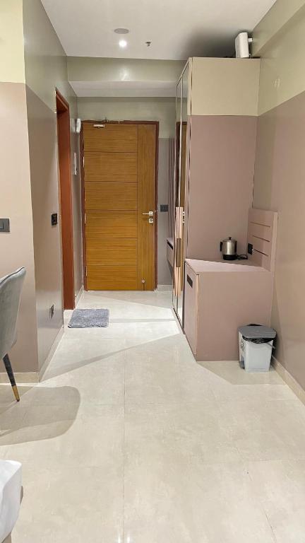a kitchen with a wooden door in a room at Us Group Stays Omaxe Hazratganj in Nalmatha