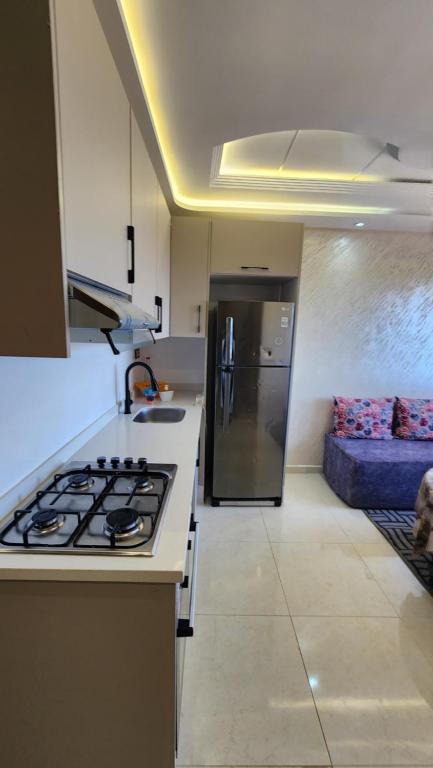 a kitchen with a stove and a couch in a room at Sidi Rahal in Sidi Rahal
