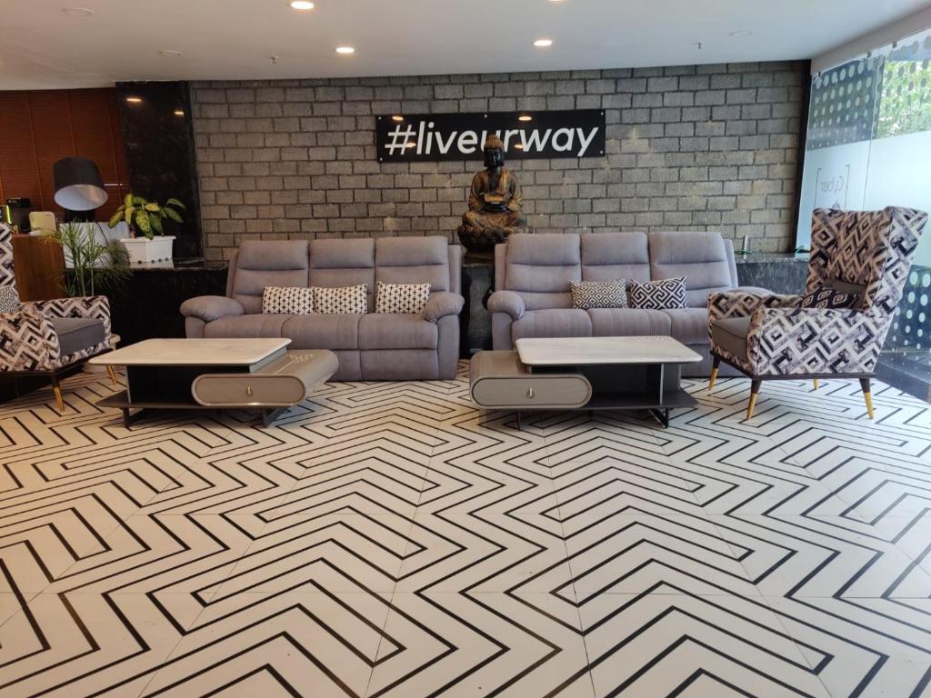 a lobby with couches and tables in a building at FlxHo Corporate Stays - Udyog Vihar in Gurgaon