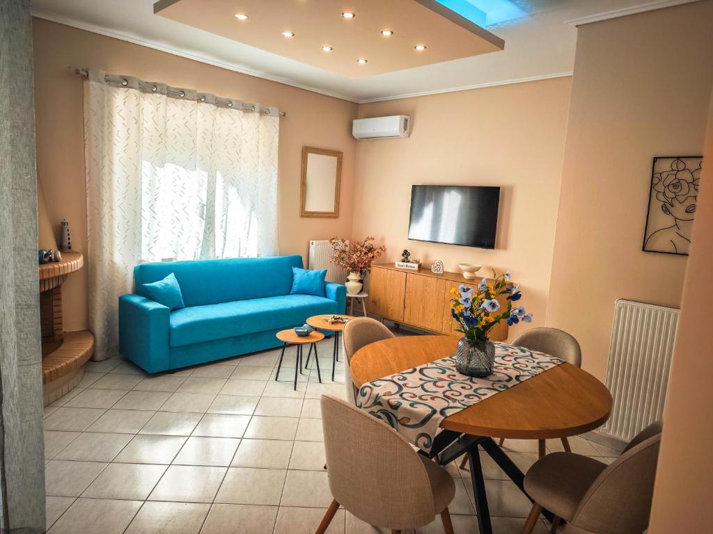 a living room with a blue couch and a table at Aelia Luxury Suites Melissi in Xylokastro