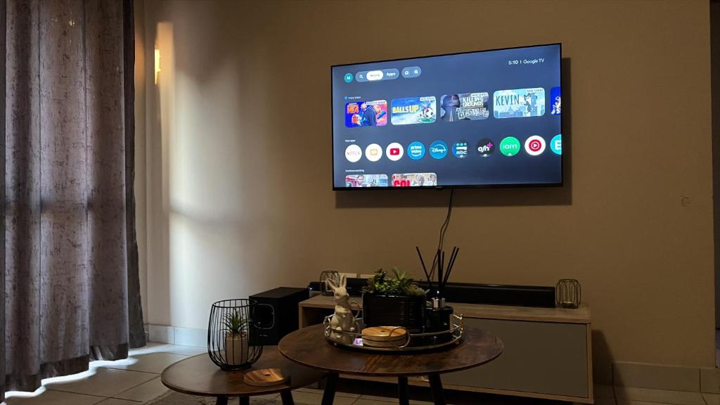a living room with a tv on the wall at Sharing living area Apartment in Centurion