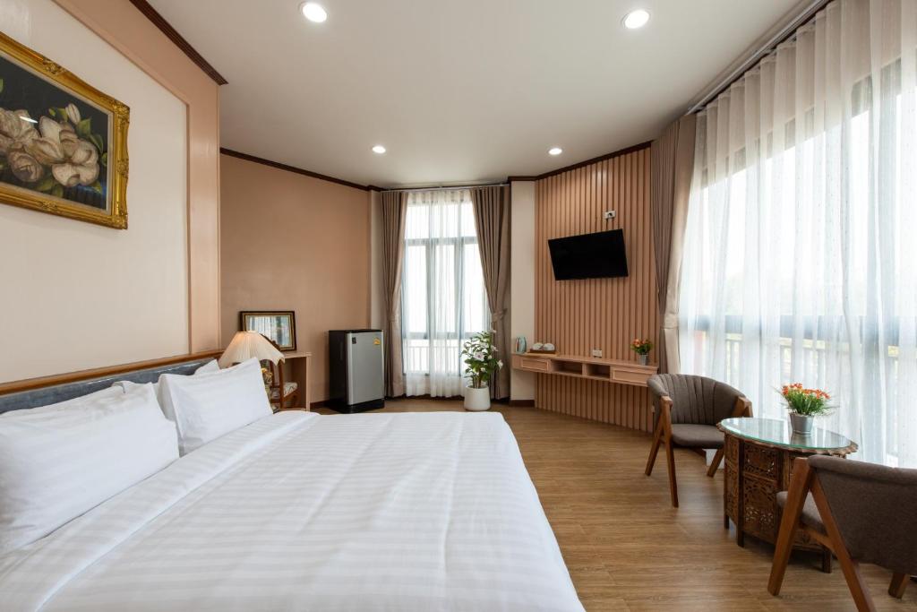 a hotel room with a large bed and a tv at Peya Rama-7 Hotel in Bang O