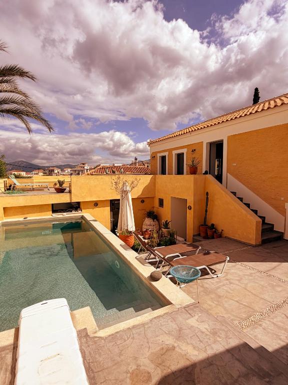 a swimming pool in front of a house at The Bellhouse Kranidi in Kranidi