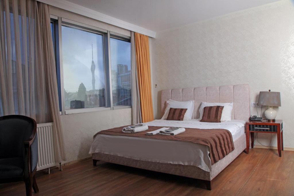 a bedroom with a bed and a large window at Çamlıca Tower Hotel in Istanbul