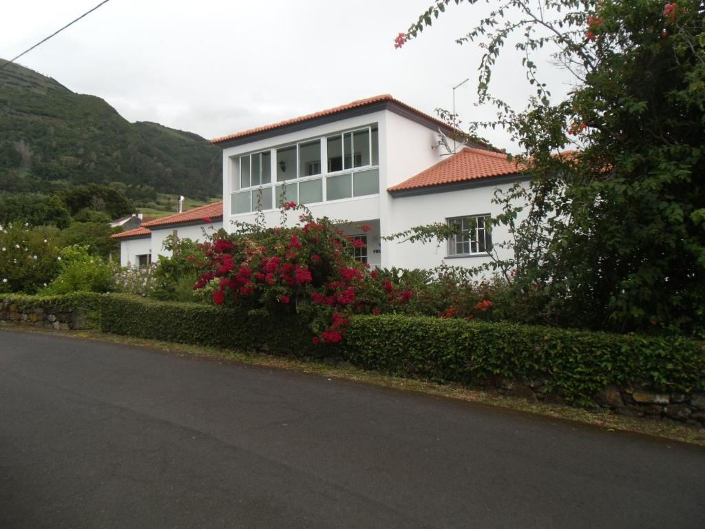 a white house with flowers in front of a street at Tropical Fruit Garden in Velas