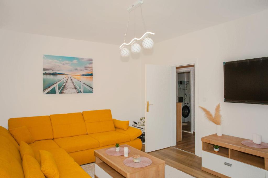 a living room with a yellow couch and a flat screen tv at Apartment Matko in Ploče