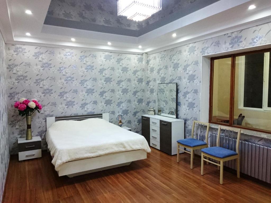 una camera con letto e carta da parati floreale blu di South Gate Apartment-2 a Bishkek