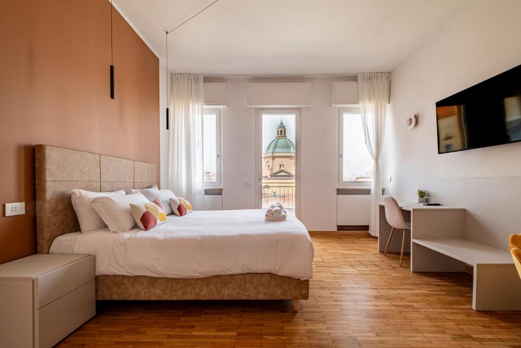 a bedroom with a large white bed and a window at Urbanicooh Cavour Rooms&Suite in Bologna