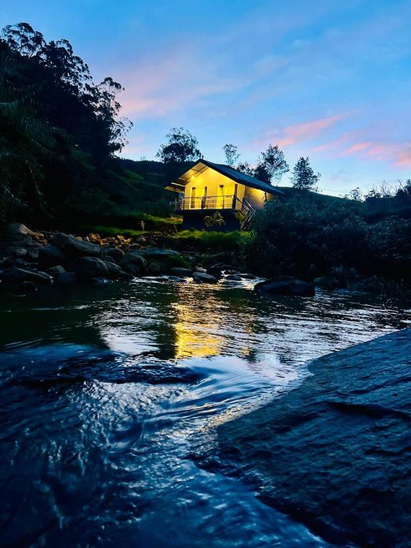 a house sitting on the side of a river at Edinburgh Cottage's in Nanu Oya