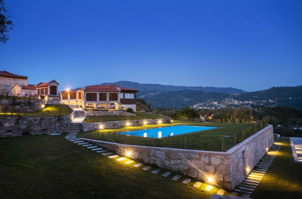 a villa with a swimming pool at night at Casas de Selim in Arcos de Valdevez