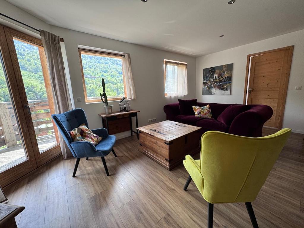 a living room with a couch and a table and chairs at Le balcon du Chemin des Vignes ! in Bozel