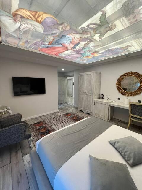 a bedroom with a large bed with a painting on the ceiling at Apera Garden in Sancaklı