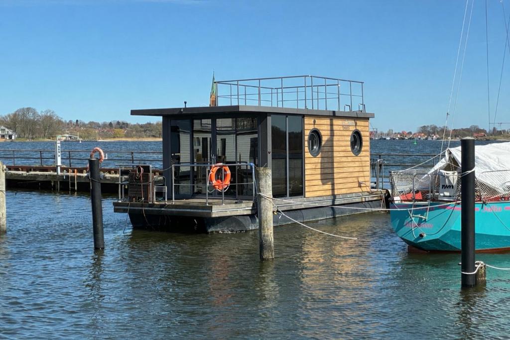 a small boat is docked at a dock at Fjord Lyckholm in Schleswig