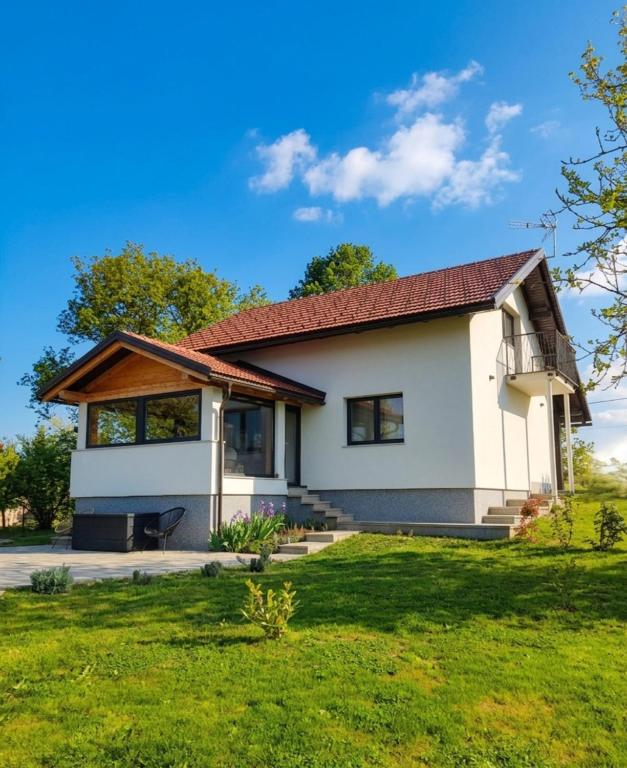 a white house with a red roof at Holiday home Poljak in Tounj