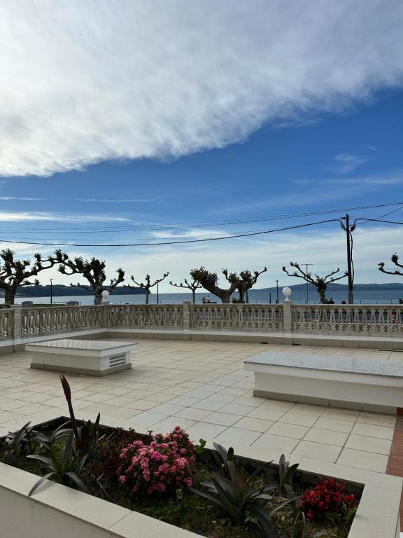 a park with two benches and a fence and flowers at Suite Playa in Miño