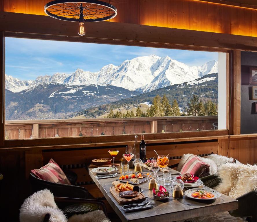 a table with food and a view of mountains at Chalet Alpen Valley, Mont-Blanc in Combloux