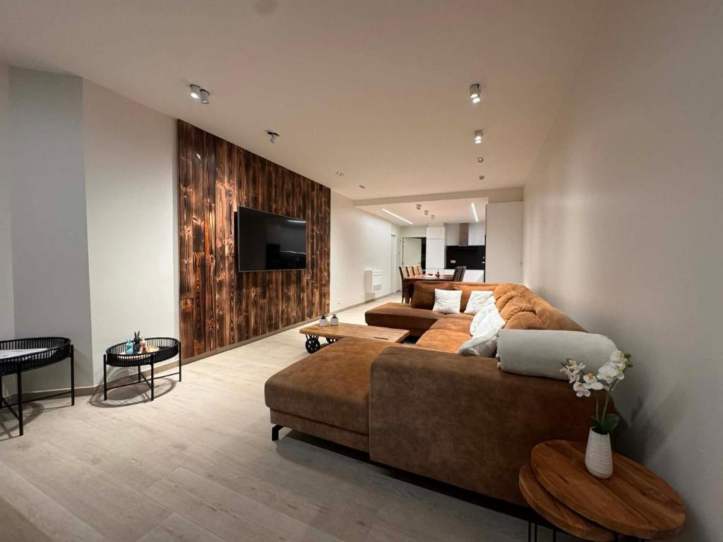 a large living room with a couch and a tv at Art Donna met zeezicht in Middelkerke