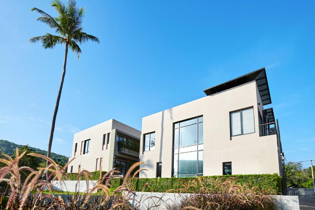 a building with a palm tree in front of it at Pause on Samui Residences in Bophut