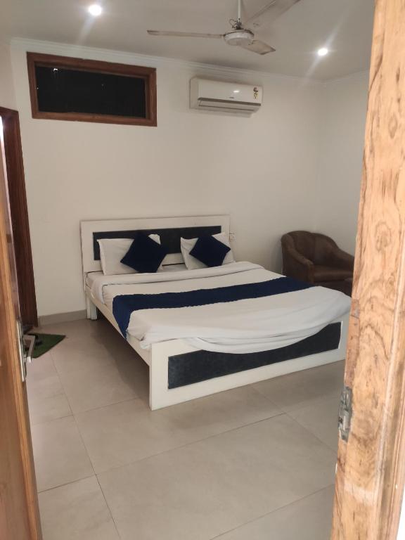 a bedroom with a large bed with blue and white pillows at Hotel Chandigarh Elite in Chandīgarh