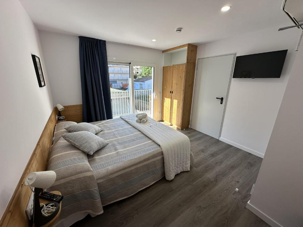 a bedroom with a large bed and a large window at Malva Hostel Estartit in L'Estartit