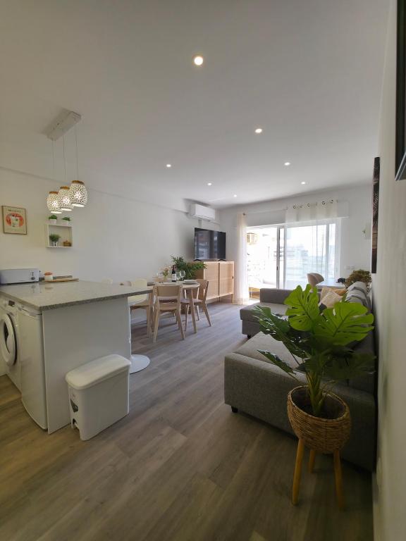 a living room and kitchen with a couch and a table at Casa Bella Arch, 2 min walk to beach Praia da Rocha in Portimão