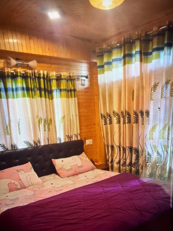 a bedroom with a large bed with curtains at Jakhu heights B&B in Shimla