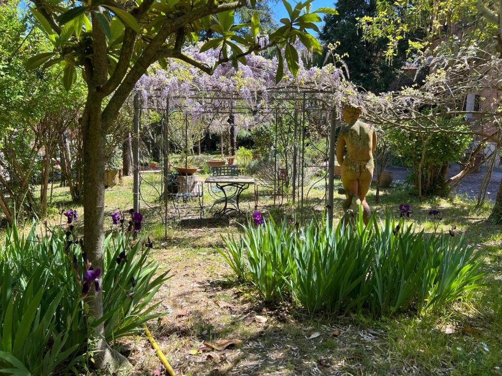 a mannequin walking through a garden with purple flowers at VILLA La Pineta di Sinalunga, vicino a Montepulciano e Val D'Orcia in Sinalunga