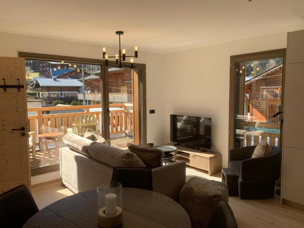 a living room with a couch and a television at Dents Blanches B103 by Avecoeur in Morzine
