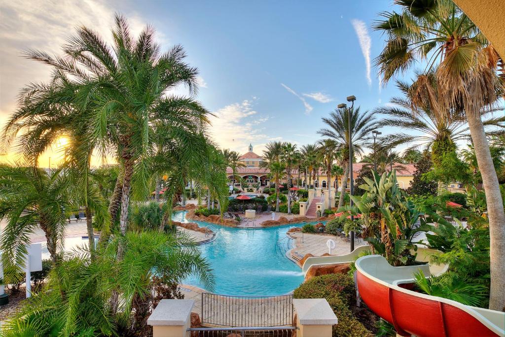 a view of a resort with a swimming pool and palm trees at 25% Off 3BR Disney Area Villa in Davenport