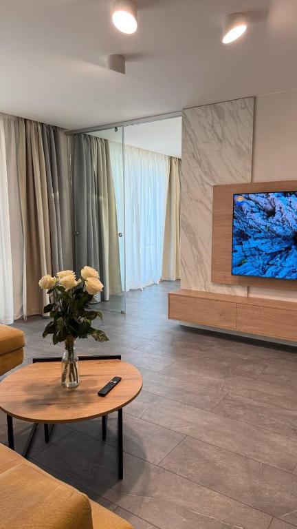 a living room with a vase of flowers on a table at Апартамент АТЕА in Kavarna
