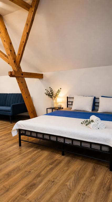 a large bed in a room with wooden floors at Centrum Rosenbaum in Beroun